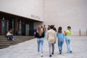Naklejka premium Group of students going in and out of the study library to prepare for university exams. Concept: Studies, education, training