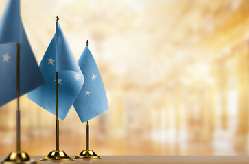 Small flags of the Federated States Micronesia on an abstract blurry background