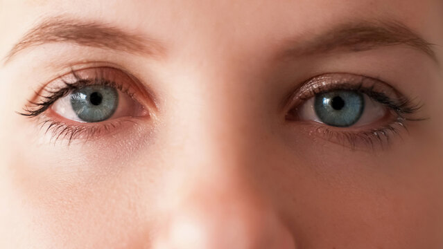 Eyes closeup. Vision eyesight. Ophthalmology correction. Cropped woman face with blue iris natural makeup sad tired pensive look.