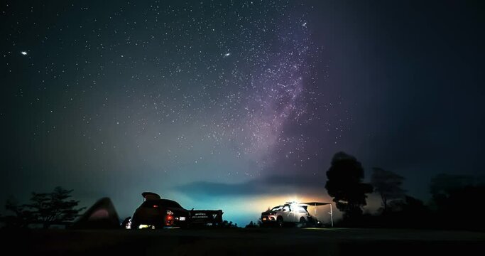 Milky way timelapse over camper car parked at campsite on top peak of Doi Kad Phee, Chiang Rai, Thailand, December 2022