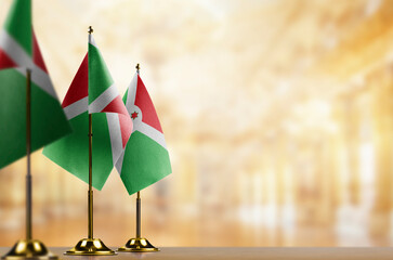 Small flags of the Burundi on an abstract blurry background