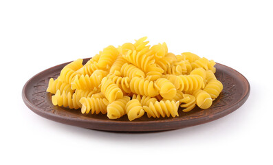Fusilli pasta on brown round plate, white background, close-up