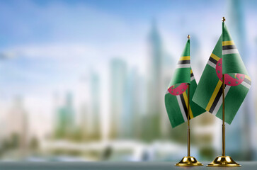 Small flags of the Dominica on an abstract blurry background