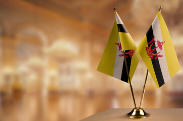 Small flags of the Brunei on an abstract blurry background