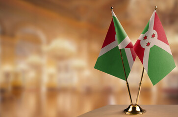 Small flags of the Burundi on an abstract blurry background