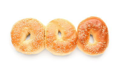 Tasty bagels with sesame seeds on white background