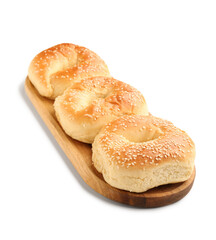 Wooden board of tasty bagels with sesame seeds on white background