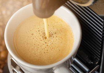 Pouring fresh morning coffee with espresso machine and sunlight and raw aroma beans