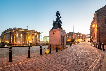 Illuminated view of Town hall in a Yorkshire Street with War memorial Sculpture in Oldham City, UK