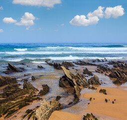 Fototapeta na wymiar Rock formations on sandy beach (Algarve, Costa Vicentina, Portugal).
