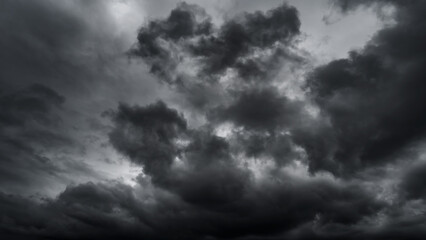 dark dramatic sky with black stormy clouds before rain or snow as abstract background, extreme weather, the sun shines through the clouds, high contrast photo