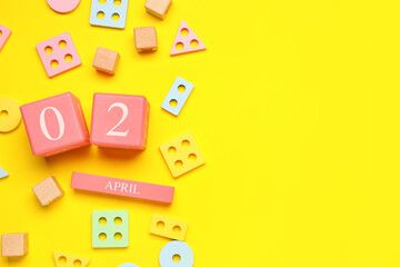 Date of World Autism Awareness Day with baby toys on yellow background