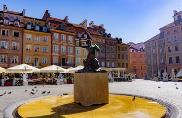 Fototapeta na wymiar Main square of the city of Warsaw with the statue of the little mermaid in the middle, on a sunny day.