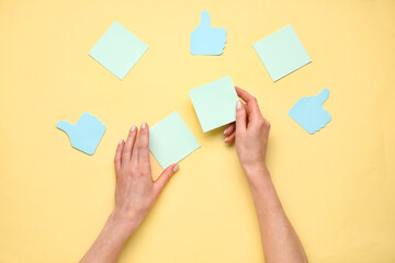 Woman holding sticky notes on yellow background