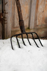 Close-up of an old pitchfork with a wooden handle, an agricultural tool. 