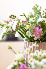 Two modern design vases with flowers like daisies and freesias in spring. Countryside spring flowers, nature and floral beauty..Spring time, colorful greenery and change of season