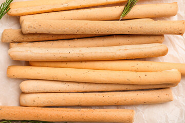 Tasty Italian Grissini on parchment paper, closeup