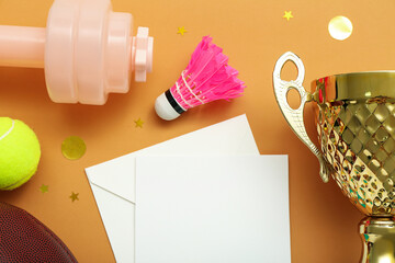 Blank card with gold cup, sports equipment and confetti on orange background