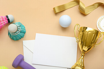 Blank card with gold cup and sports equipment on beige background