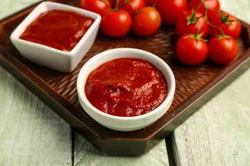 Bowl with tasty tomato paste on table