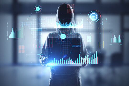 Hacker holding laptop with glowing digital business interface with charts on blurry office interior background. Infographic, hacking and big data concept. Double exposure.
