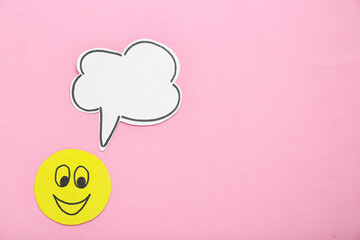 Paper smile with speech bubble on pink background. Dialogue concept