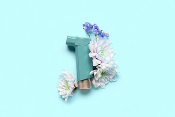 Asthma inhaler with flowers on blue background