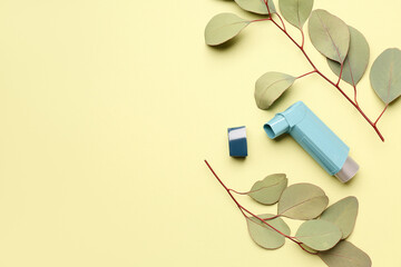 Asthma inhaler with eucalyptus branches on green background