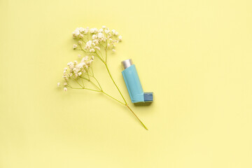 Asthma inhaler with flowers on green background