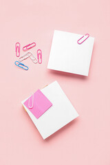 Obraz na płótnie Canvas Sticky notes with paper clips on pink background