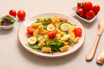 Plate of tasty potato salad with eggs and tomatoes on light background