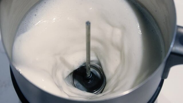 froth milk slow motion, milk in a blender close-up, Creamy milk swirling in blender, Super slow motion, Mixing milk