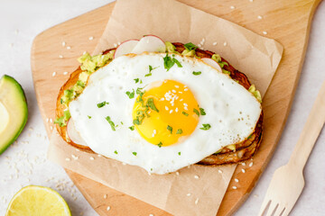 Delicious sandwich with fried egg on light background
