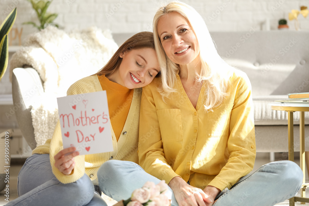 Poster Young woman greeting her mother with card at home