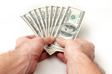 Pile of one hundred dollars banknotes  in male hands on white background close up - 590900715