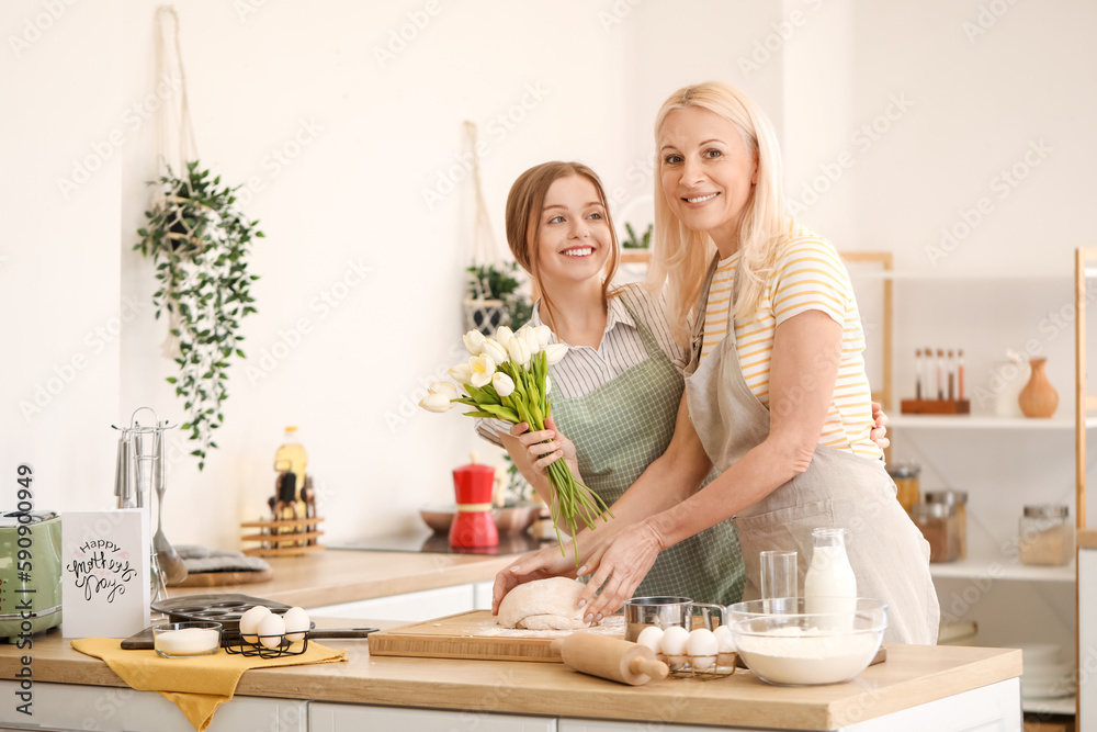 Poster Young woman greeting her mother with tulips in kitchen