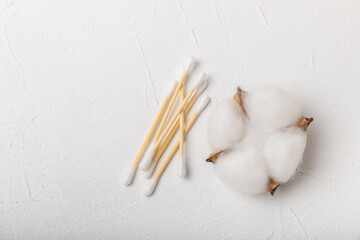 Fototapeta na wymiar Cotton swabs on a white cement background. Bamboo cotton buds. Means for hygiene of ears. Eco-friendly materials.Hygienic cotton ear buds.
