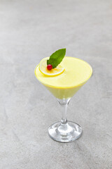 Italian dessert. Lemon cream jelly, Panna Cotta in a martini glass. Light gray background. Copy space