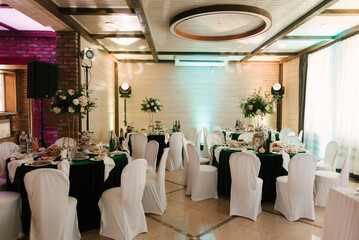 Tables are beautifully decorated with tablecloths and flowers for the event wedding
