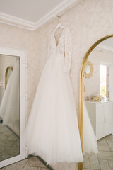 Beautiful white wedding dress of the bride hanging on a hanger