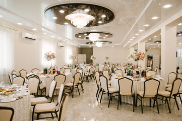 The large bright hall is decorated with flowers for the event, wedding decor