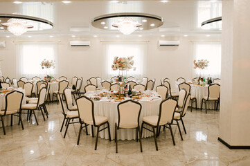 The large bright hall is decorated with flowers for the event, wedding decor
