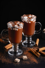 Two cups of hot chocolate, cocoa or warm drink with marshmallows on dark background