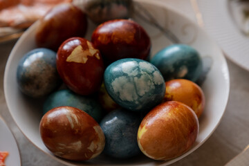 Glossy Easter eggs coloured with natural bio ingredients in brown, yellow, and light blue colours