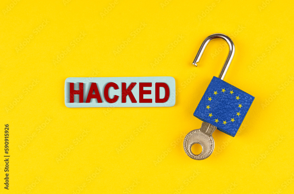 Poster On the yellow surface is an open lock with a key and a sticker with the inscription - hacked