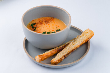 Creamy lentil soup with cheese grissini, spices and microgreens.