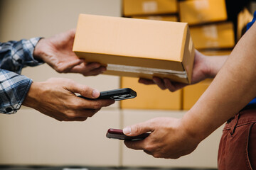 Startup small business entrepreneur of freelance Asian woman using a laptop with box Cheerful success Asian woman her hand lifts up online marketing packaging box and delivery SME idea concept