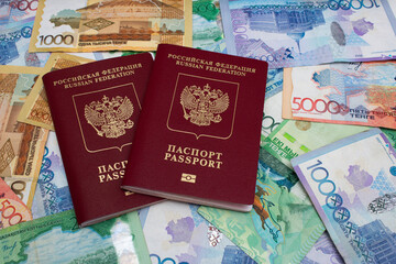 Russian biometric red passport. Modern multicolored cash paper banknotes of Republic of Kazakhstan. Kazakh money to pay for purchases, credit, debt. Concept of salary, tourism, travel. 5000 tenge. 