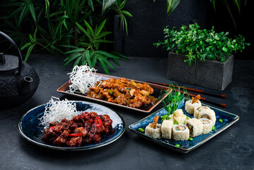 Asian lunch set of chicken with onion, celery, cashew nuts, pork in Thai sweet chili sauce and sushi roll set with shrimps tempura, cucumber, onion.