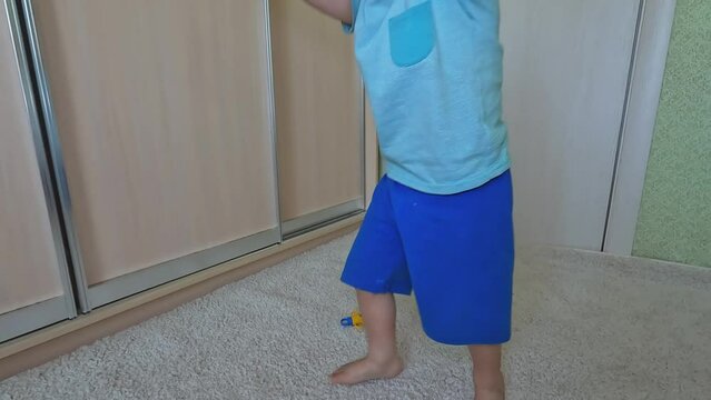 A child plays with the hands of a toy clock at home. An inquisitive boy studies objects. Copy space - children's math development concept, learning center, counting skills, elementary school, educatio